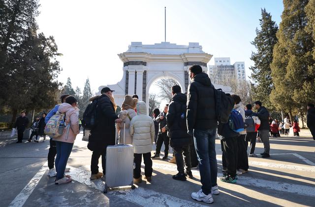 游客在清华大学校园内了解二校门的历史.新京报记者 李木易 摄