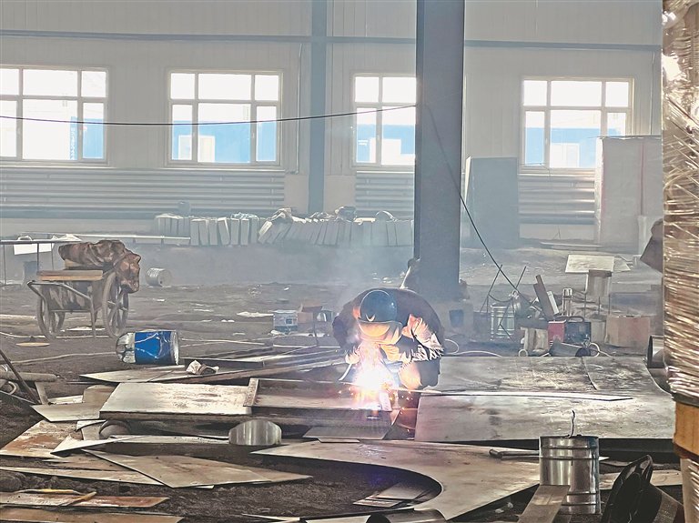 百春固废煤矸石综合利用项目2号厂房,工人进行燃气管道焊接.杨崴摄