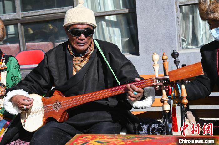 西藏萨迦县特困人员集中供养中心,一位老人在弹奏藏族传统乐器扎念琴