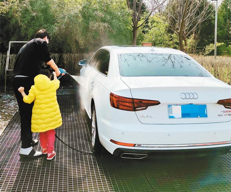 一名车主在使用自助洗车设备清洗车辆