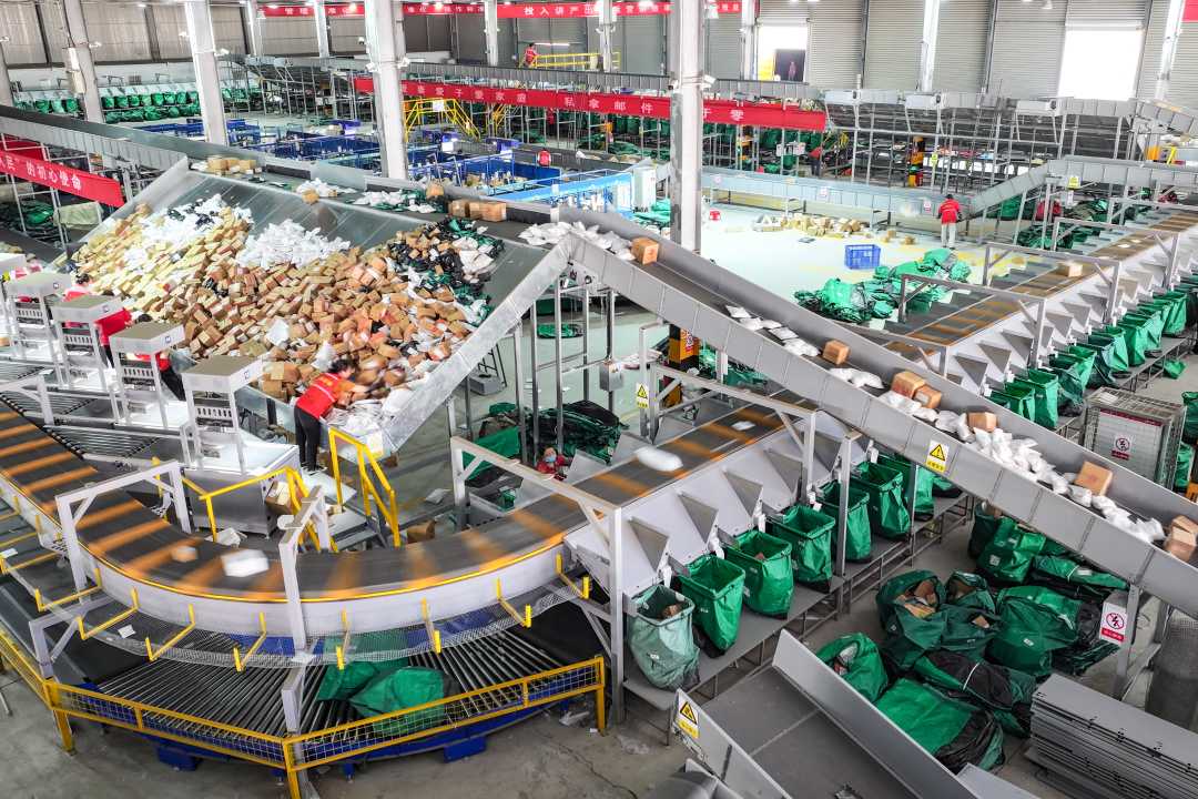 宿迁市沭阳县邮政包裹快递庙头处理中心分拣车间内,工作人员对快递