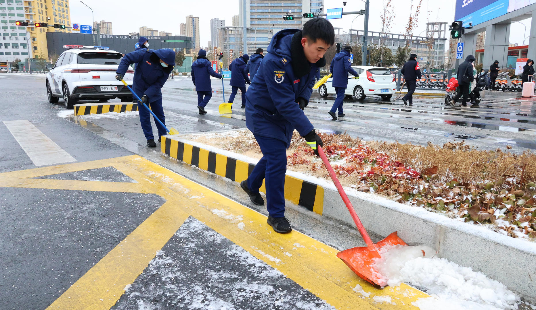 ▲2月1日，江苏连云港，铁路连云港站前广场，志愿者在清扫路面积雪。据视觉中国