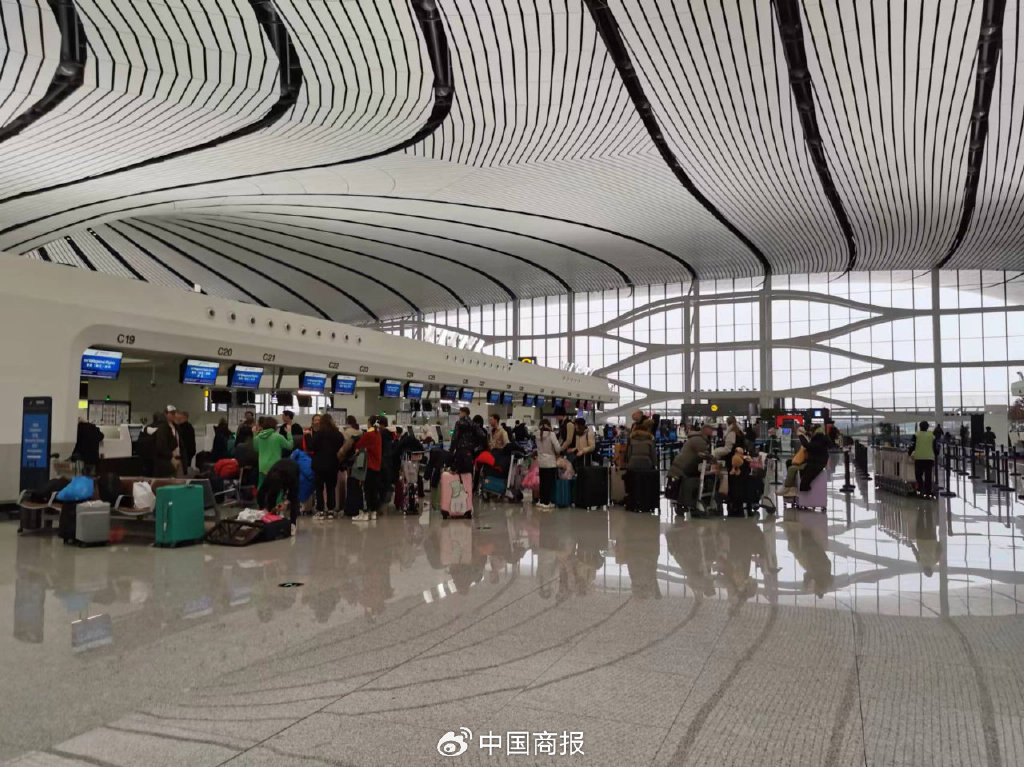 在北京大兴机场内,旅客正排队等候值机和行李托运.