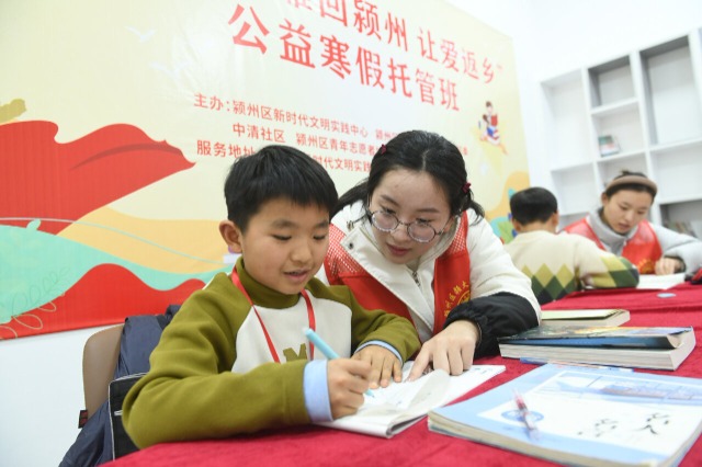 大学生志愿者指导小学生们辅导作业 王彪 摄