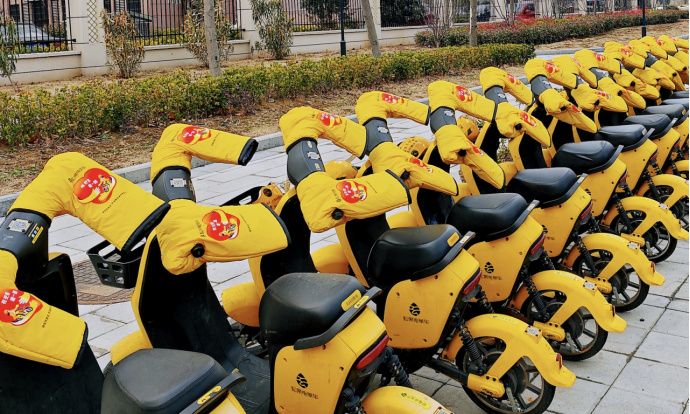 上装暖冬手把套的松果电单车整齐停放在路边