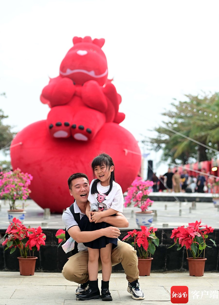 　　游客在 “在三亚 过大年”2024三亚年货节大东海主会场和“龙小福”合影。记者 沙晓峰 摄