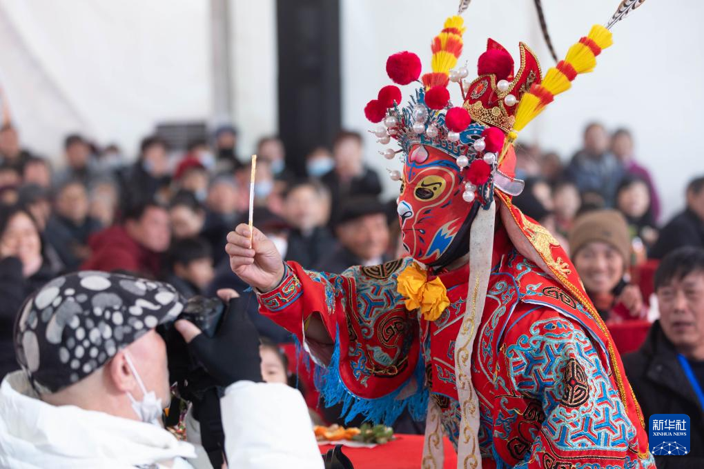 变脸演员在村晚现场与观众互动