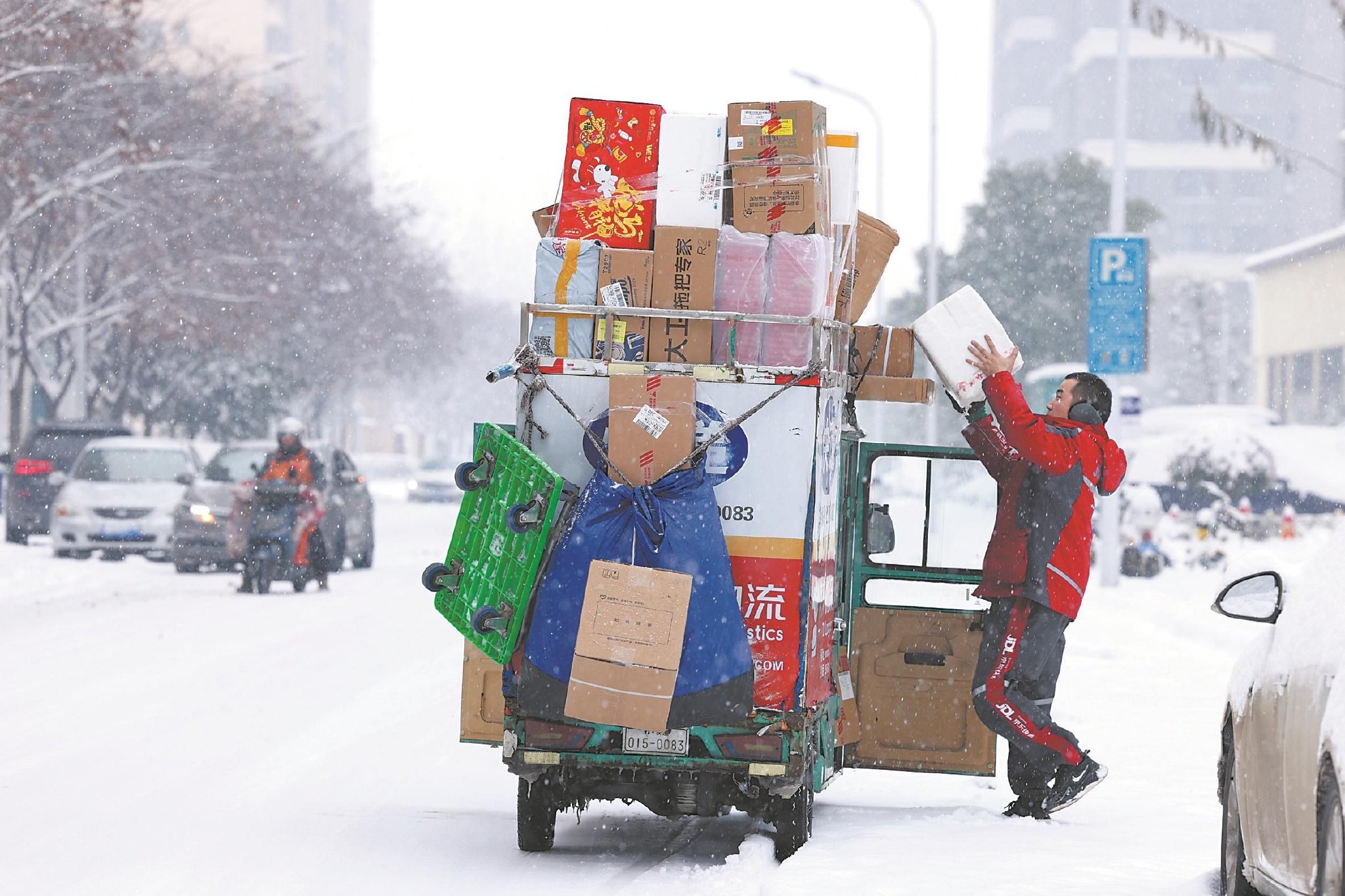 2月4日上午,蚌埠市延安路附近,一名快递小哥在雪中送快递.