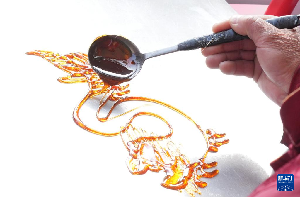 2月5日,民间艺人在制作龙形糖画.