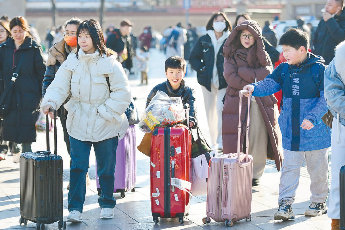 图为北京站广场上,小朋友推着行李箱踏上春运路.本报记者 邓伟 摄