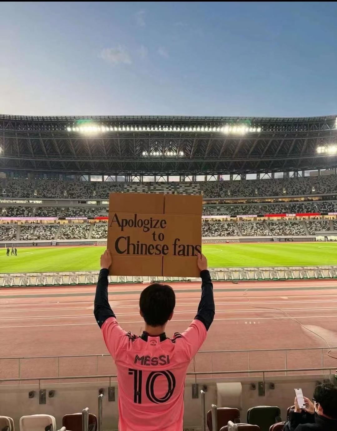 现场有人举着写有“Apologtze to Chinese fans（向中国球迷道歉）”字样的纸牌进行抗议