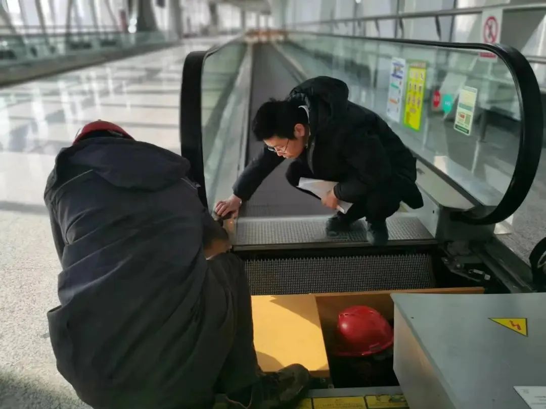 图说:特种设备管理员李靖(右一)对电梯设备进行维保