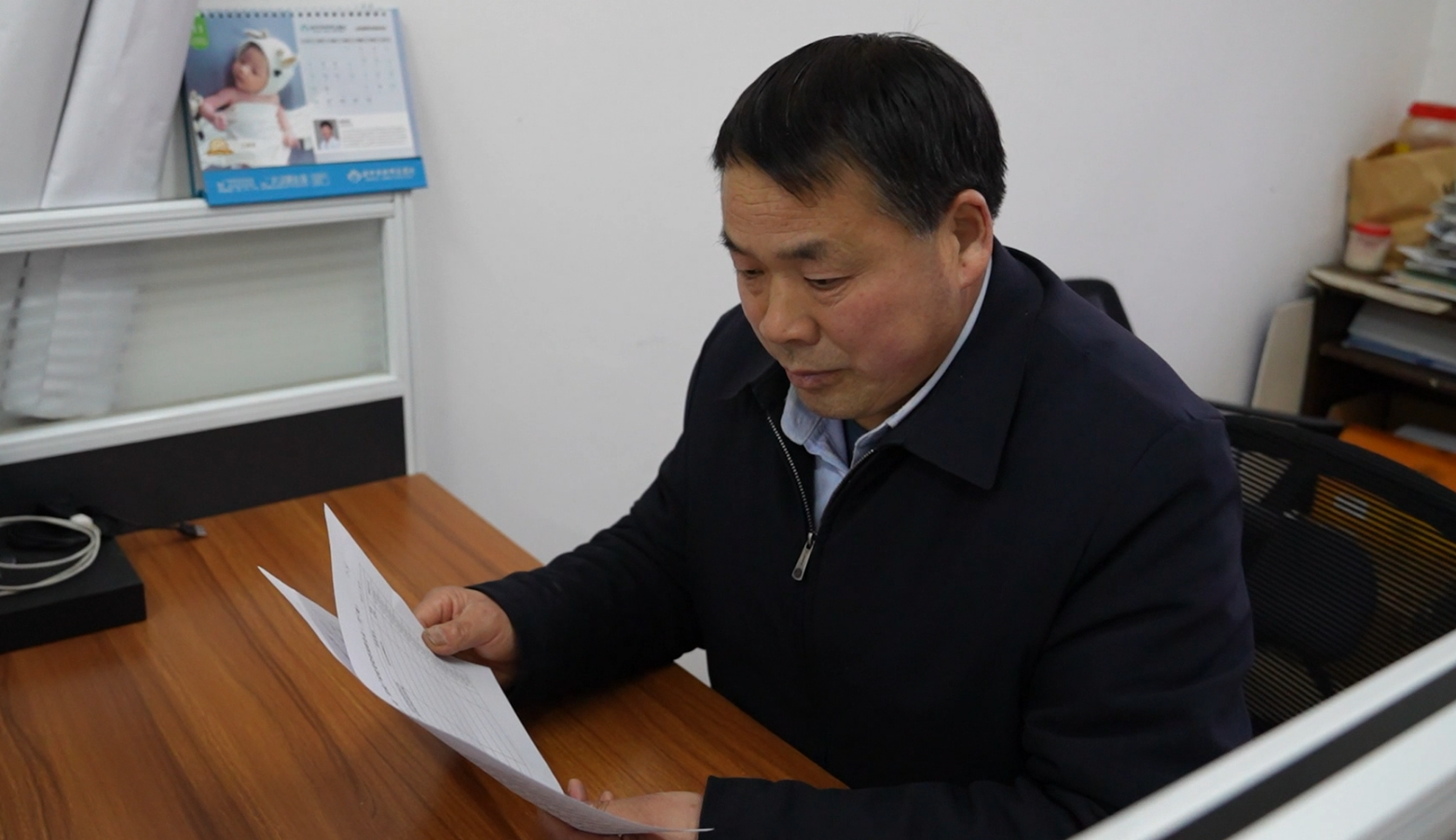 夏道华在村委会办公室查看报表