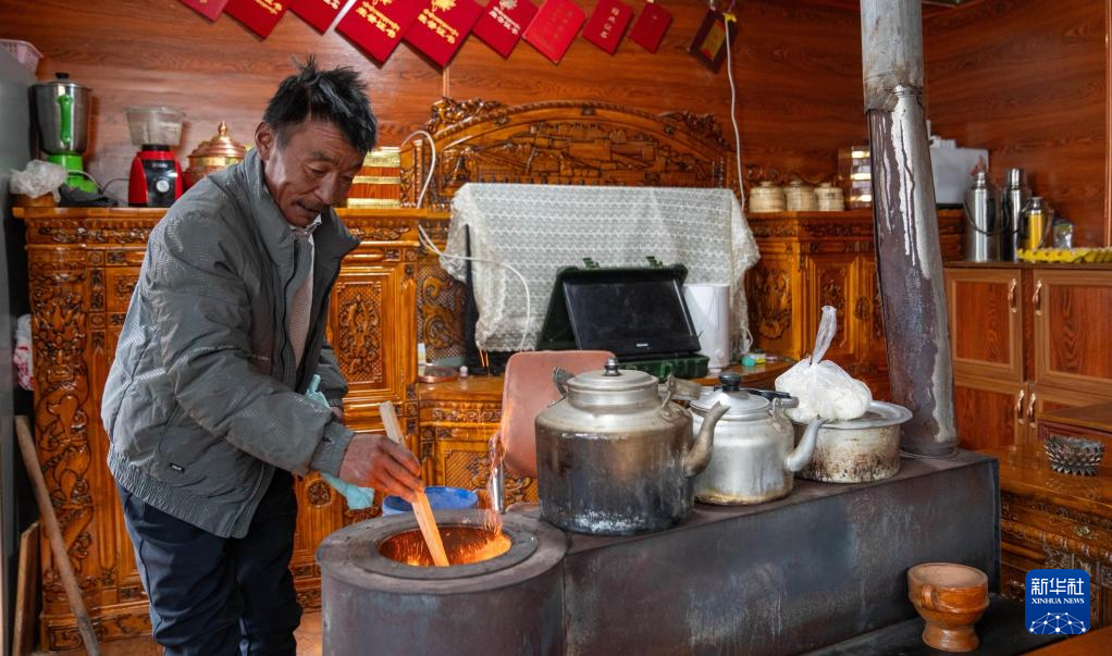 顿珠次旺在家里烧炉子取暖.新华社记者旦增尼玛曲珠摄
