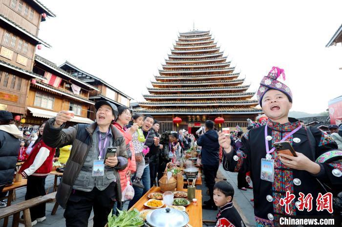 在广西三江侗族自治县林溪镇程阳八寨景区,游客们在体验侗族百家宴.