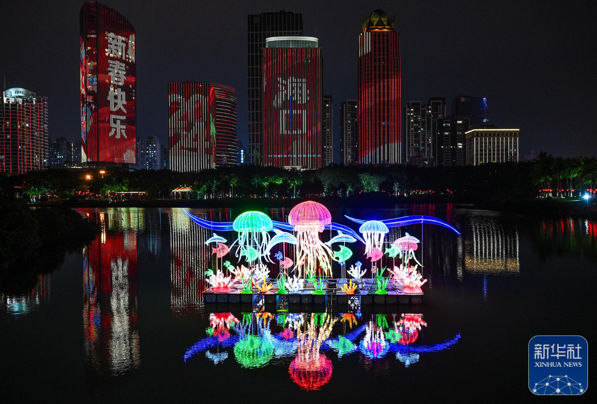 2月10日在海口市万绿园拍摄的万春会花灯和滨海大道高层建筑灯光秀.