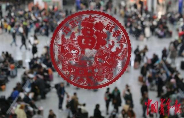 2月12日，重庆北站候车大厅二楼环廊的玻璃上贴着龙年生肖的窗花。中青报·中青网记者 陈剑／摄