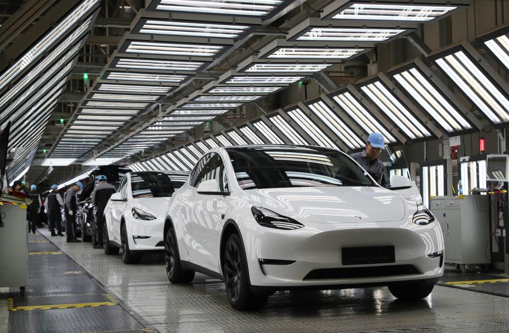 2023年12月22日,在特斯拉上海超级工厂内,工人在对出厂前的车辆进行