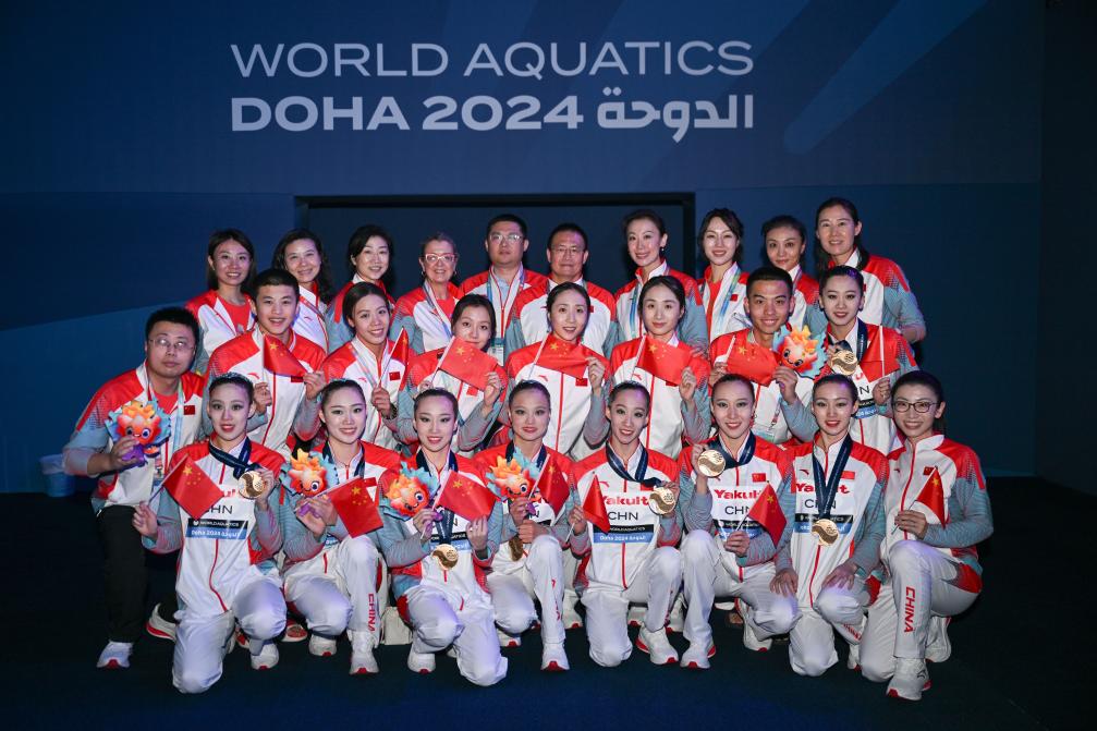 2月9日,中国花样游泳队成员在集体自由自选夺冠后合影.
