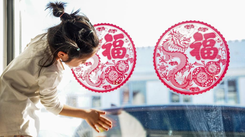 吉林省舒兰市开原镇新开村村民在家中贴窗花.新华社记者 颜麟蕴 摄