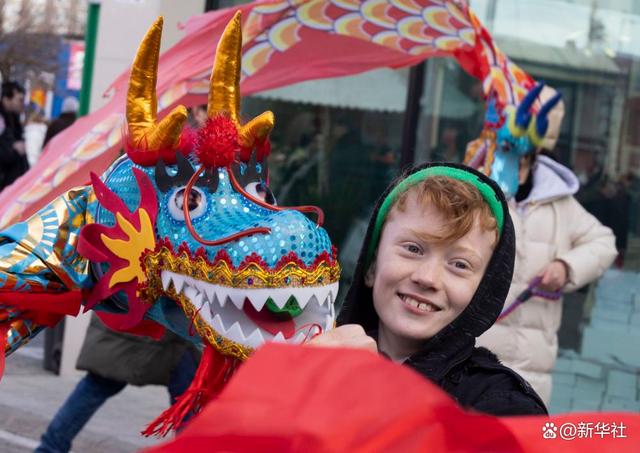 匈牙利男孩在布达佩斯唐人街新春庙会上体验舞龙(2月3日摄).