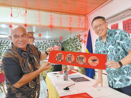 中国驻瑙鲁使馆参赞王旭光和瑙鲁朋友展示春联.梁碧娇摄