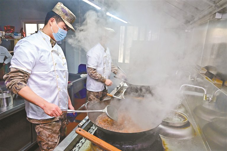 部队炊事员在炒菜. (光明区退役军人事务局供图)