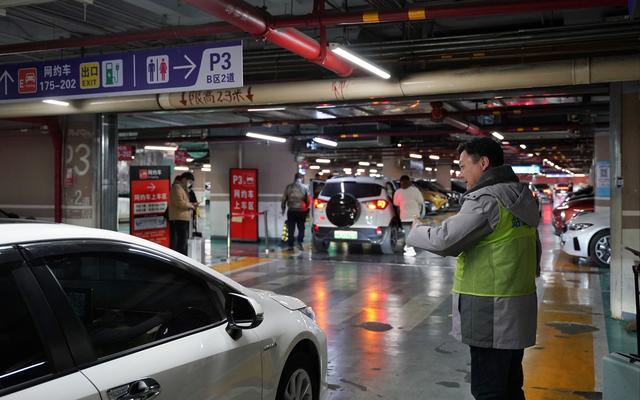 2月14日晚上10点,北京西站p3停车场内,工作人员正在指引接站车辆贴着