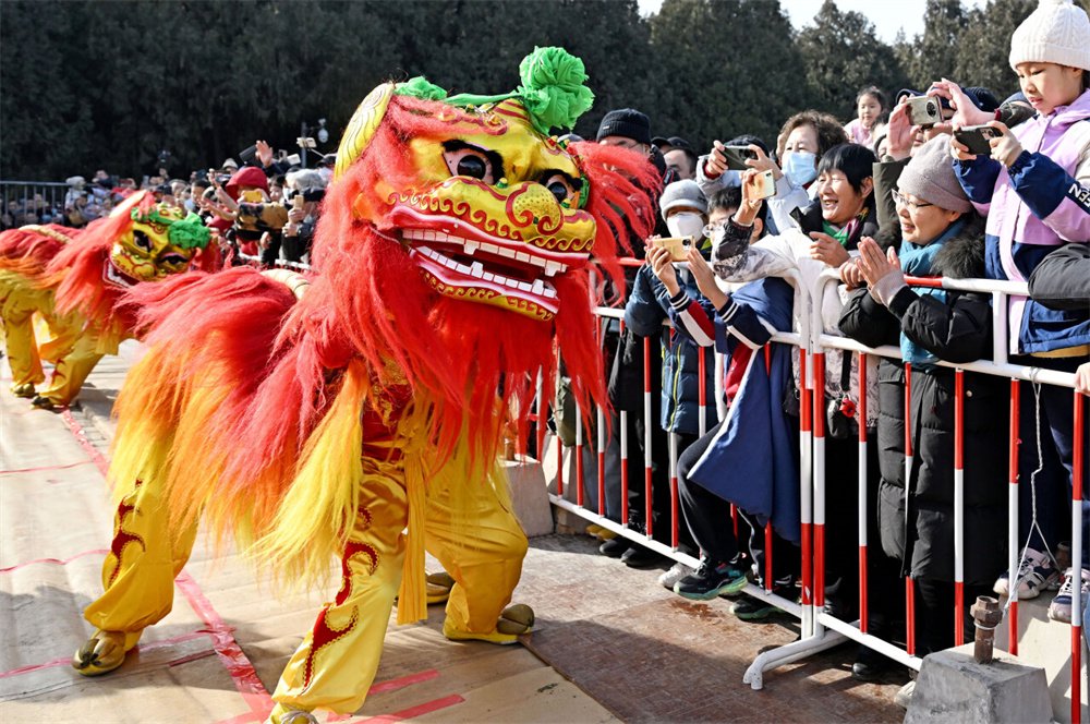 2月11日,沧县刘吉舞狮团的演员在北京地坛春节文化庙会上与现场观众