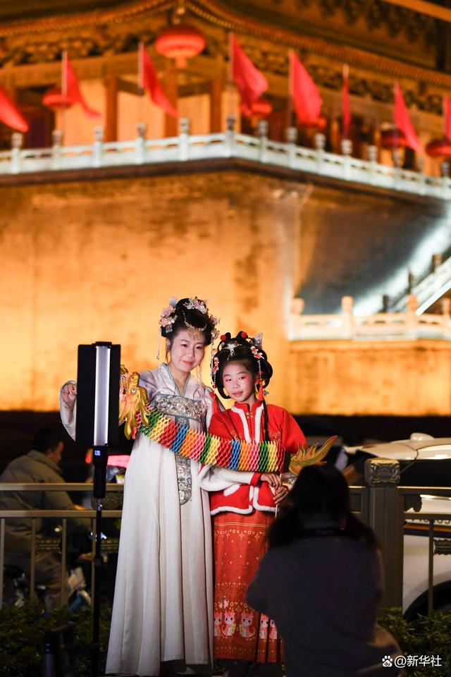 2月13日,游客身穿汉服在西安市钟楼景区"打卡"留影.