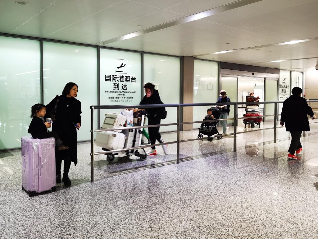 2月14日,游客走出上海虹桥机场国际港澳台到达出口.