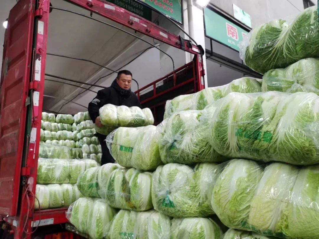 装卸工人麻利地将蔬菜搬运到运输车上.