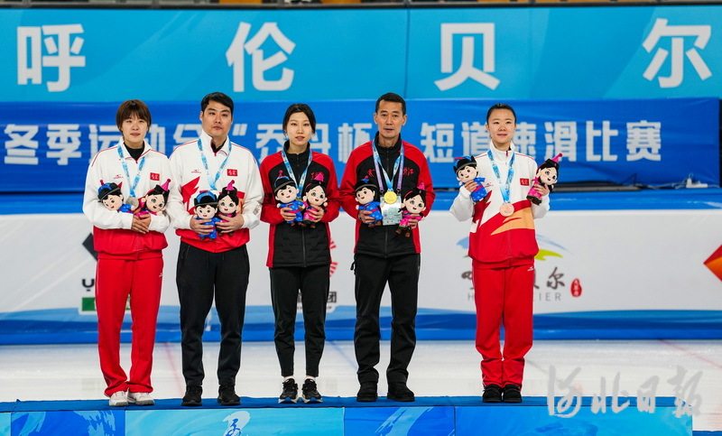 河北与黑龙江联合培养的运动员臧一泽(左三)与教练员(右二)站在领奖台
