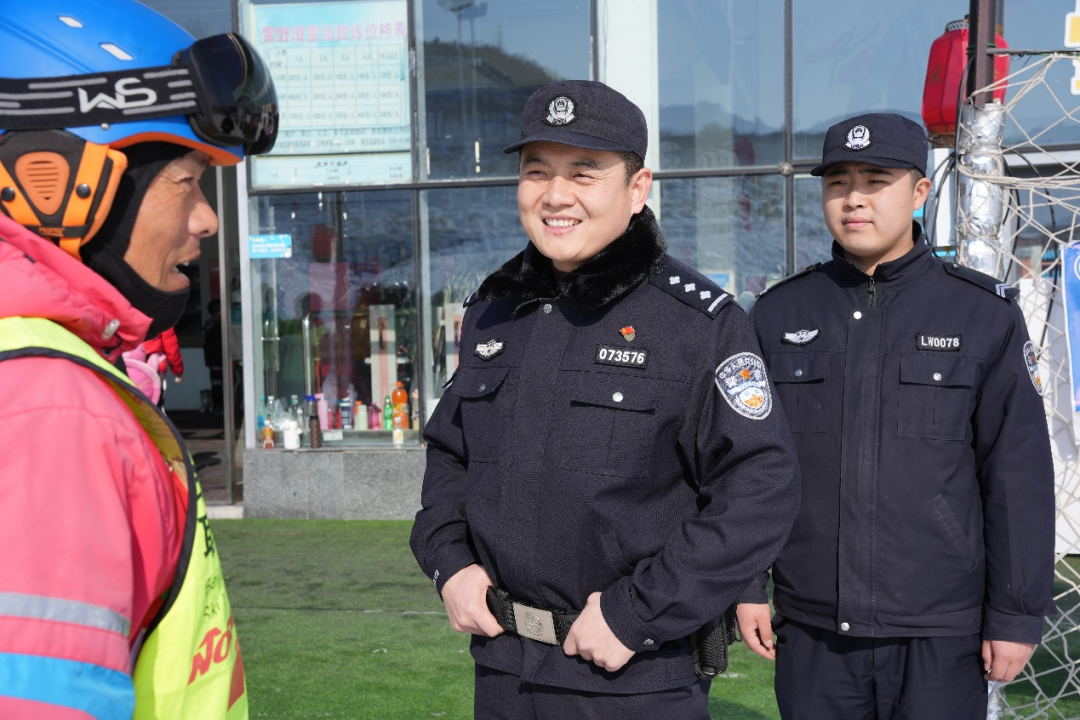 雪野派出所副所长王蒙(中)与滑雪场教练交流,了解雪场内游客流量和