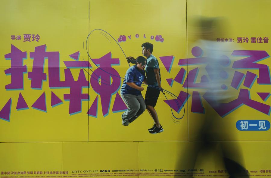 2月16日,观众从杭州一家影院的春节档电影《热辣滚烫》海报前走过.