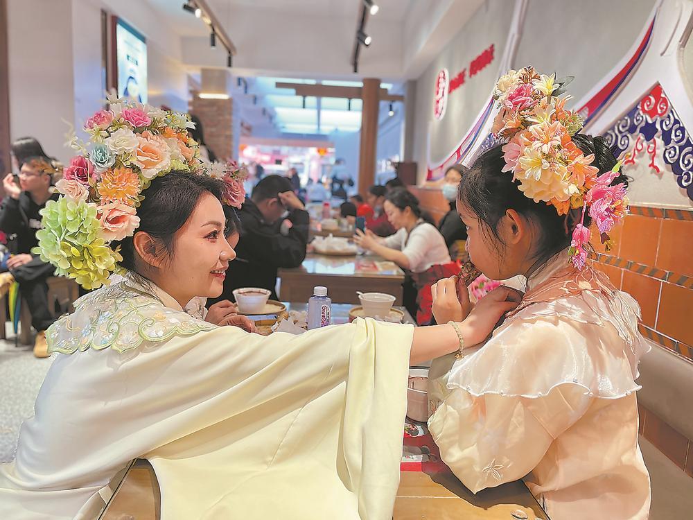 头戴簪花围,身着特色服饰的游客,成为泉州中山路一道亮丽风景.