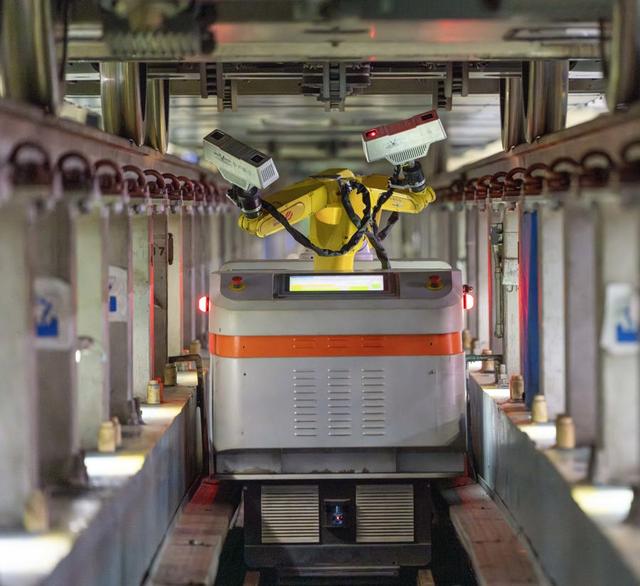 上海虹桥动车运用所检修库内，智能动车检修机器人在检修高铁列车。解放日报 孟雨涵 摄