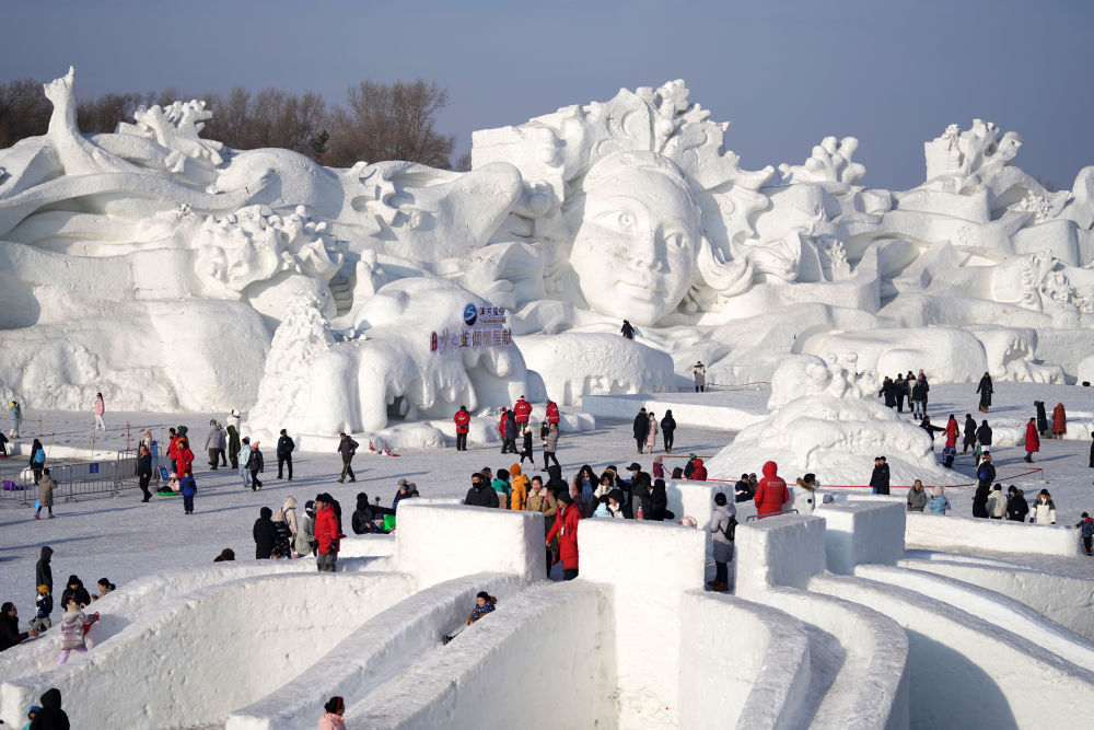 2月13日,游客在哈尔滨太阳岛雪博会园区内体验冰雪娱乐项目.