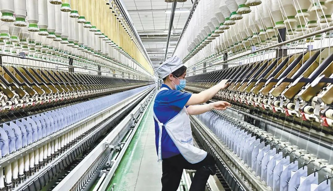 2月18日,在咸阳纺织集团有限公司一分厂细纱车间,纺织女工在进行接头