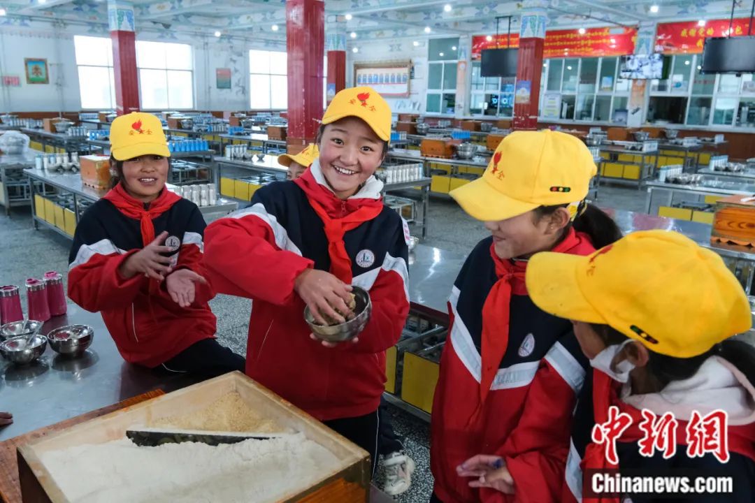 西藏班戈县中石化小学学生在学校食堂捏糌粑。江飞波摄