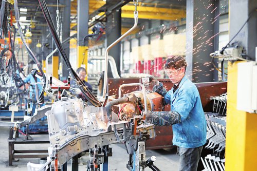 图为在安徽省合肥市肥西县桃花镇一家机械企业生产车间内,工人在生产