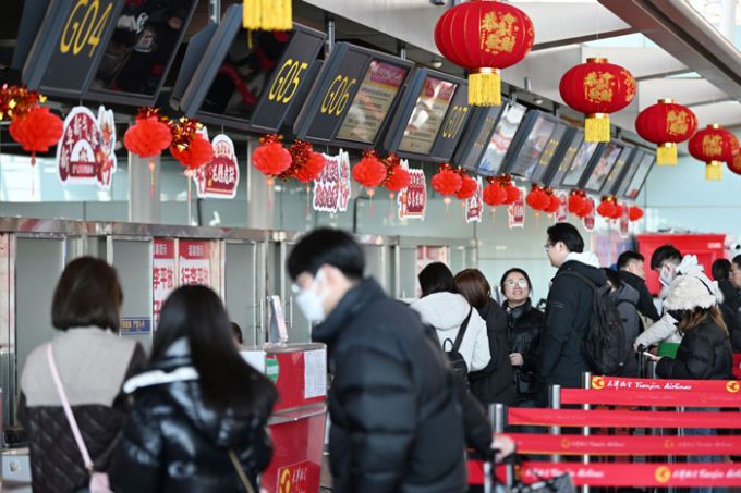 2024年1月26日，旅客在天津滨海国际机场排队办理值机。图片来源：新华社