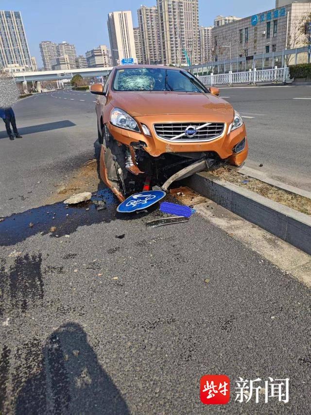 图为事故发生的现场在巨大的冲击力下,小轿车将隔离带前的一根标志牌