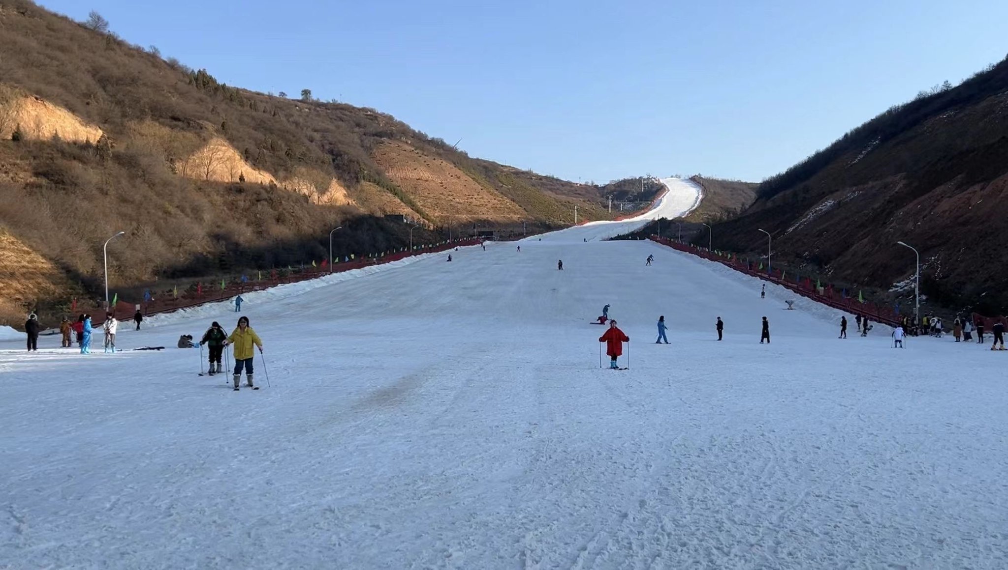 在平凉市崆峒区海寨沟滑雪场,高低不同的雪道上,滑雪爱好者一个个飞驰