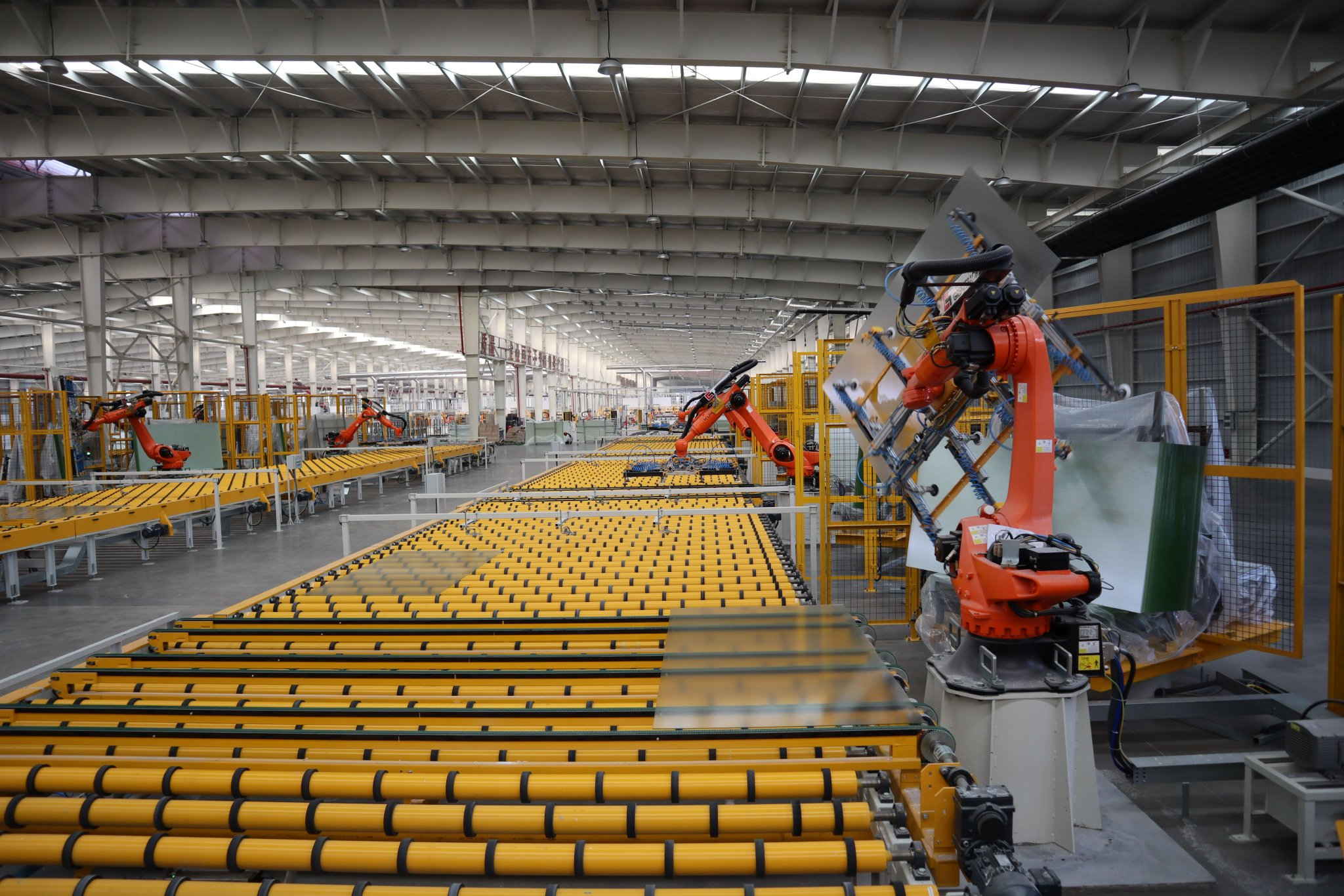 贵州黔玻永太新材料有限公司生产车间,机械手将光伏玻璃抓取到货架上.
