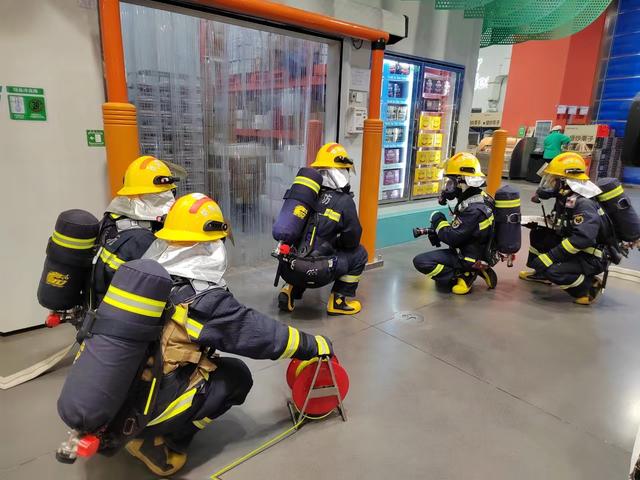 消防员手持水带准备进入超市灭火.图源:顺义区消防救援支队