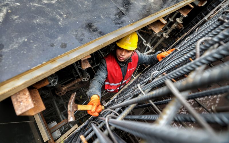 一位工人在狭窄的作业空间内绑扎钢筋.新京报记者 王贵彬 摄