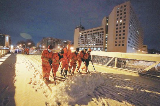 昨天凌晨5点，西城环卫工人合力清除辖区各城市干道、过街天桥等处冰雪，保障市民出行。 本报记者 方非摄