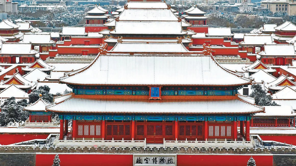 登高欣赏一夜飞雪后的故宫，红墙白雪相映衬，给游客带来一份穿越时空的感受。 本报记者 白继开摄
