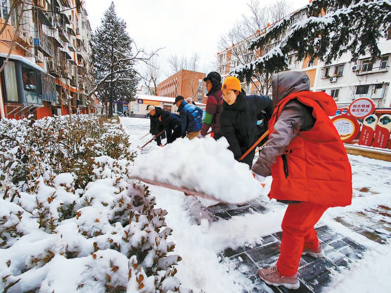 石景山区古城街道南路东社区的老街坊们齐心协力，扫雪铲冰，清理出居民出行的“绿色通道”。本报记者 吴镝摄